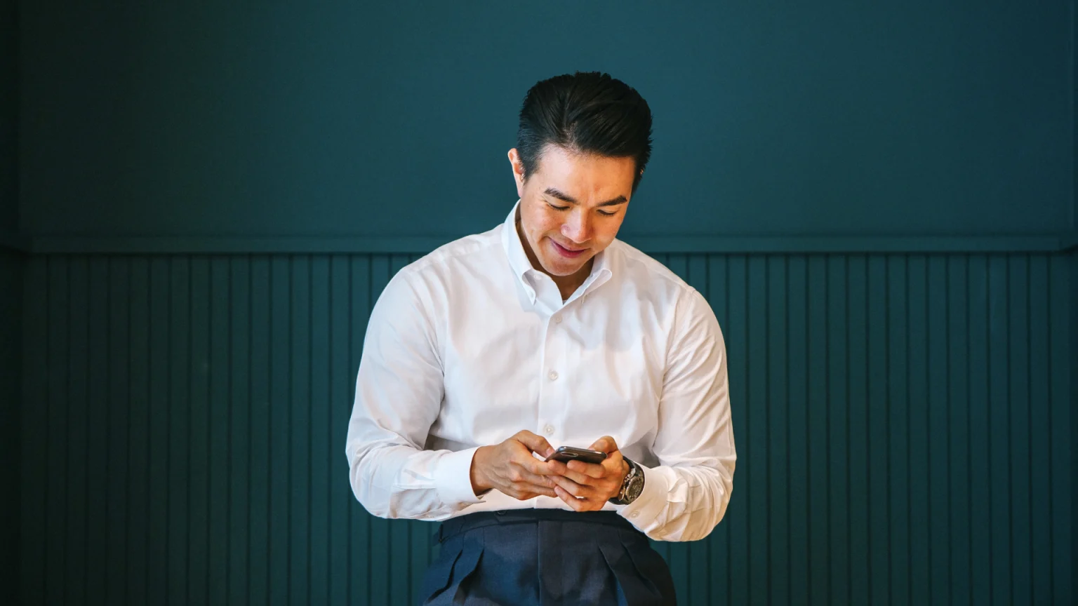 Man in white shirt using smartphone
