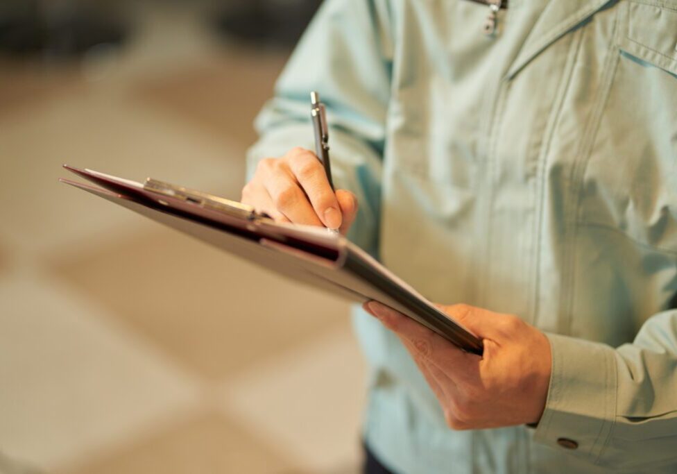 Worker taking notes on clipboard