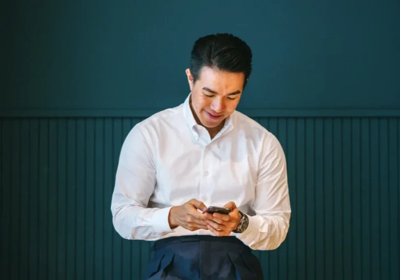 Man in white shirt using smartphone